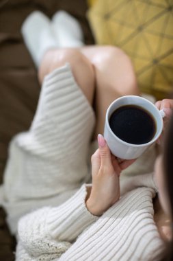 Huzurlu ve huzurlu bir an. Evde sıcak bir fincan kahve ve rahat bir örgü ile güzel bir şekilde çekilmiş.