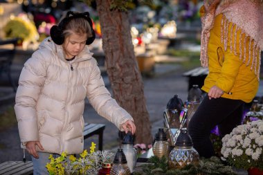 A beautifully serene moment of remembrance at a peaceful cemetery adorned with colorful flowers and glowing lanterns clipart