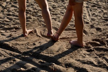 Güzel kumlu bir ortamda, iki çift ayak birbirine dolanır ve aralarında özel bir bağ kurarlar.