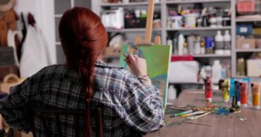 Bir sanatçı, güzel tablosunu ilham verici sanat malzemeleriyle dolu canlı bir stüdyoda tasarlıyor.