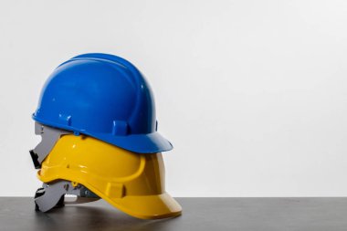 Mavi ve sarı bir miğfer bir araya toplanmış, inşaat endüstrisinde güvenli yerleri vurguluyor.