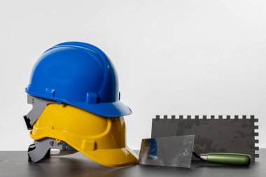 Önemli iş yeri güvenlik uygulamalarını vurgulayan inşaat şapkaları, aletler ve güvenlik teçhizatının canlı bir görüntüsü