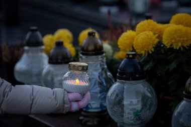 Mumlar ve canlı sarı çiçeklerle dolu sakin bir sahne, derin anılar ve kalpten bir anıt.
