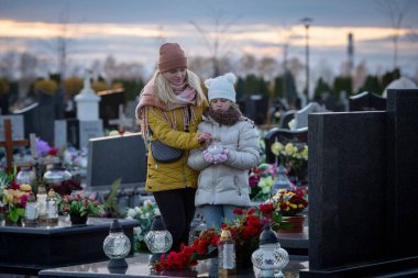 Bir anne ile kızının mezarlıkta kaybettikleri sevdiklerini onurlandırdıkları son derece dokunaklı ve içten bir an.
