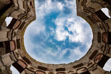 Dinamik bir gökyüzüne karşı kurulmuş yıpranmış ve tarihi bir mimari yıkıntının çarpıcı güzelliğini keşfedin ve keşfedin.