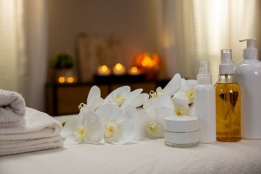 Düzenlenmiş havlular, mis kokulu yağlar ve dinlenmek ve gençleşmek için zarif çiçekler olan sakin bir spa sahnesi.