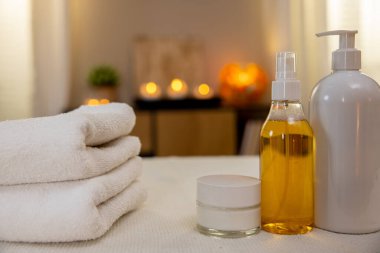 Yumuşak havlularla süslenmiş huzur verici ve rahatlatıcı bir spa seti ve sağlıklı olmayı teşvik eden gerekli yağlar.