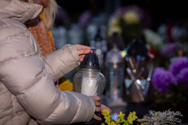 Güzel ve huzurlu bir hatıra anı, taze çiçeklerin yanına nazikçe yerleştirilmiş bir fenerle gerçekleşir.