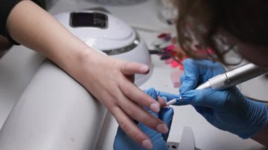 Son derece yetenekli bir tırnak teknisyeni hassas aletleri kullanarak ustaca tırnak sanatını icra ediyor.