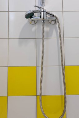 Bu şık duş düzeneği parlak bir krom duş başlığı içeriyor. Parlak sarı fayanslara karşı çok güzel duruyor.