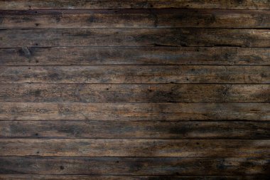 Çarpıcı bir görüntü koyu ahşap bir zemini ön plana çıkarıyor, desenli bir yüzeyi var, etkileyici arka planlar için ideal.