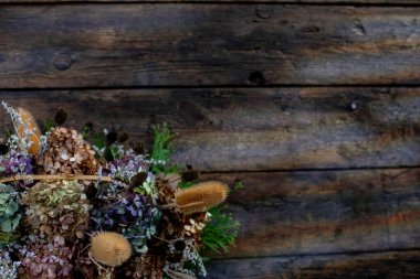 Büyüleyici ve güzel, kurumuş bir çiçek aranjmanı. Kırsal ahşap bir zemin üzerine kurulmuş. Dekorasyon için ideal.