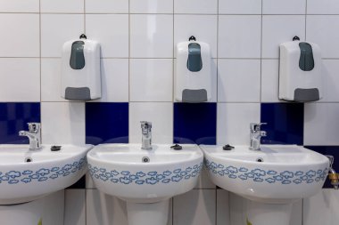 Bu şık umumi tuvalet modern lavabo ve yenilikçi sabunluklarla tasarlandı.
