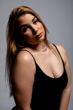 Etkileyici ve çarpıcı bir portre hem özgüveni hem de zarafeti bir minimalist arkaplana yansıtıyor.