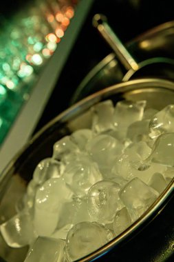 A captivating closeup of ice cubes in a bowl, enhanced by vibrant ambient lighting for a stunning visual effect clipart