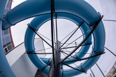 Şaşırtıcı bir mavi su kaydırak spiral görüntüsü, yukarı doğru benzersiz tasarımı vurguluyor.