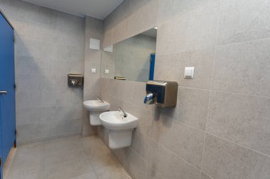 Bu çağdaş banyoda kullanıcı kolaylığı için çift leğenler ve verimli el kurutma tesisleri bulunmaktadır.