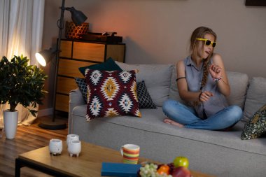 Evde kaygısız bir rahatlama anının tadını çıkarıyorum, hoş bir atmosferde hoş müzik ve atıştırmalıklarla şımarırken.