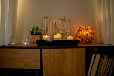 Zarif düzenlenmiş mumlar, dekoratif bitkiler ve rahat bir atmosfer için sıcak bir ışıklandırma.