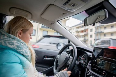 Arabasını kullanan kendine güvenen bir kadın, yenilikçi araç tasarımı ve kentsel yaşam deneyimi sergiliyor.