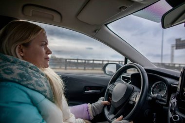 Kararlı ve odaklanmış bir kadın zorlu ve fırtınalı bir arazide aracını ustalıkla sürüyor.