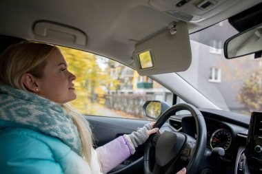 Neşeli bir kadın gülümsüyor ferahlatıcı ve serin bir sonbahar gününde, göz kamaştırıcı bir sonbahar yapraklarıyla çevrili.