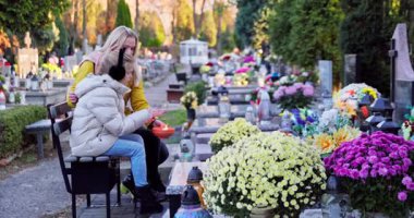 Canlı çiçeklerle süslenmiş huzurlu bir mezarlık, hatıra ve yansımanın derin anlarını anımsatıyor.