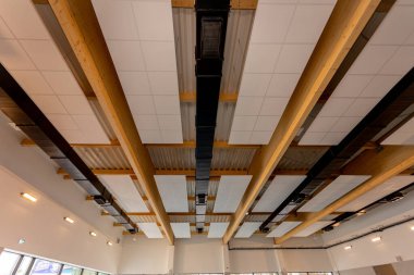 Bu şık tavan ahşap kirişler ve modern armatürler içeriyor, çağdaş bir uzayın atmosferini arttırıyor.