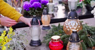 Bir insan çiçek sergisinde mum yakar. Huzuru ve huzuru huzur içinde simgeler.