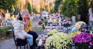Huzurlu ve huzurlu bir mezarlık sahnesi ziyaretçilerle dolu anıları paylaşan, çiçek açan ve yürekten anılarla dolu.