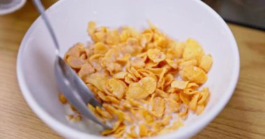 Kremalı süte batırılmış mısır gevreğinin tadını çıkarmanın zevki, sağlıklı bir kahvaltı seçeneği için mükemmel bir seçim.