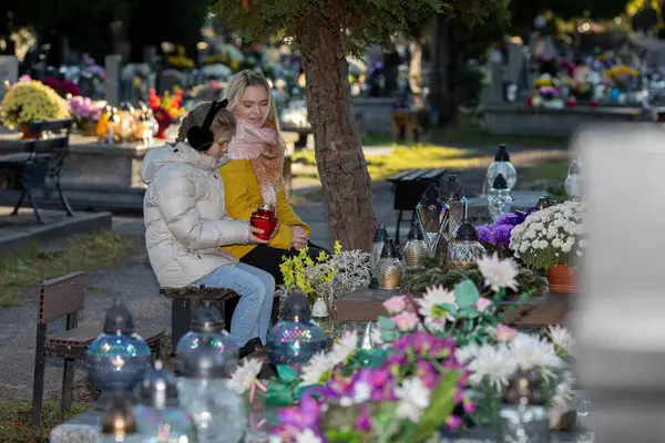 Huzurlu ve huzurlu bir sahne, mezarlıkta çiçek açan çiçekler arasında içgözlem ve derin hatıralar sergiliyor.