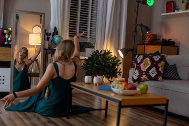 Güzel, sakin bir akşam sahnesi. Sıcak, davetkar, rahat bir oturma odasında zarif bir şekilde dans eden bir kadın.