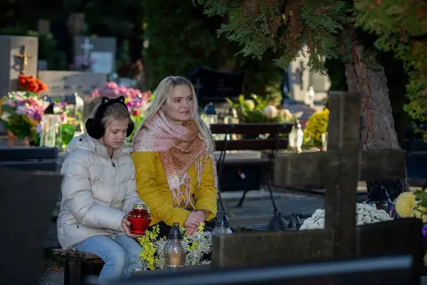 Bir mezarlıkta, iki kadın birlikte bir çiçek denizinin ortasındaki yaşamı yansıtan kutsal bir anı sessizce paylaşırlar.