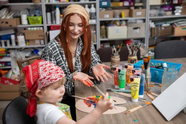 Bir çocuk ve bir sanatçı resim ve çeşitli zanaat faaliyetleri yoluyla yaratıcılığı büyük bir hevesle keşfediyorlar.