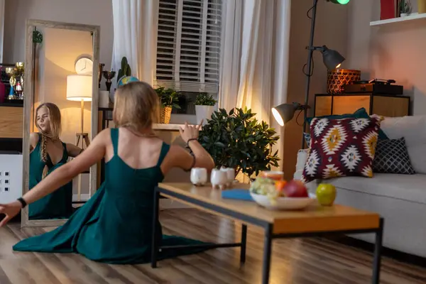 Sakin bir iç mekan sahnesinde, hoş dekorlar ve taze meyvelerle çevrili, yumuşak yeşil elbiseli bir kadın yer alıyor.