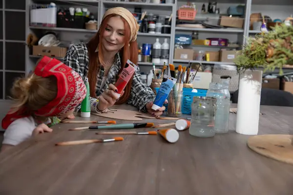 Hoş ve neşeli bir sanat oturumunda bir ebeveyn ve çocukları renkli malzemeler kullanarak yaratıcılığı keşfediyorlar.