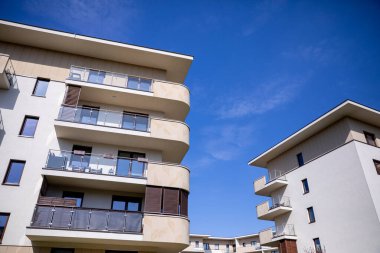 Bu parlak, açık mavi gökyüzüne karşı kurulmuş çağdaş apartman komplekslerinin büyüleyici bir görüntüsü.