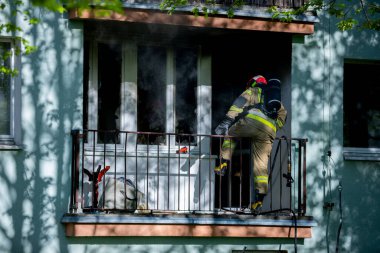 Cesur bir itfaiyeci, yerleşim yerindeki yoğun alevlerle baş etmek için kahramanca bir balkona tırmanır.