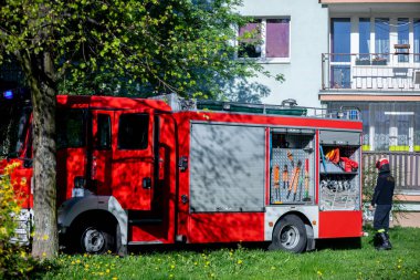 Parlak kırmızı bir itfaiye kamyonu güneşli bir günde park halinde, ortaya çıkabilecek her türlü acil duruma tam hazırlıklı.