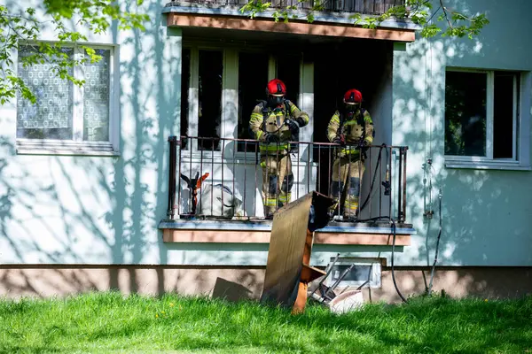 İtfaiyeciler bir yerleşim yerinde, acil durum müdahalesi sırasında cesaret ve takım çalışması sergiliyorlar..