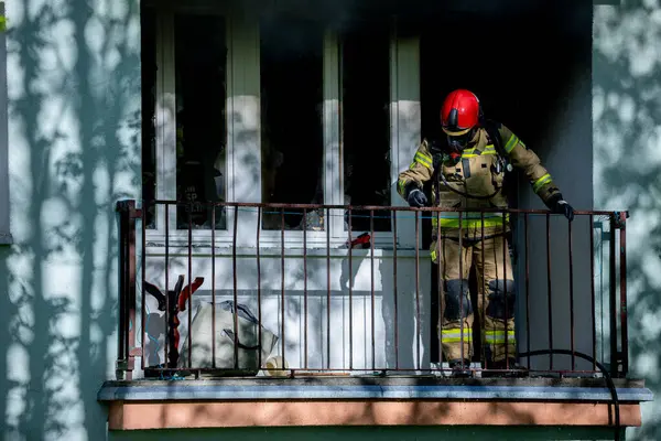 Cesur bir itfaiyeci bir balkonda duruyor ve acil bir durumla baş etmeye hazır.