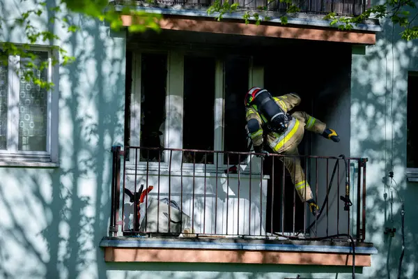 Acil bir durumda itfaiyeci yorulmadan bir kişiyi balkondan kurtarmaya çalışır.