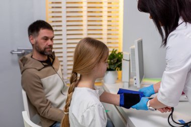 Genç bir çocuk, modern klinik ortamında rutin bir sağlık kontrolüne sahiptir.