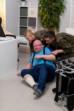 Müdahale ekipleri, ofis ortamında yaralı bir adama acil yardım sağlarken dramatik bir sahne gözler önüne seriliyor.