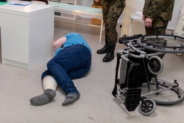 Tekerlekli sandalyenin yanında zor durumdaki bir kişi engellilerin karşılaştığı zorlukları vurguluyor..