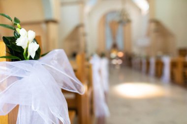 Çiçekler ve kurdelelerle süslenmiş kilise koridoru aşkı kutlamak için romantik bir sahne hazırlıyor.