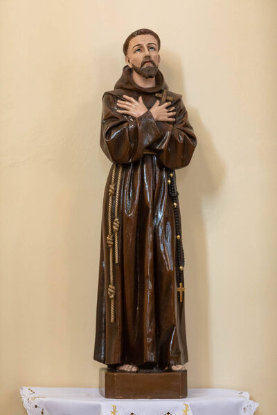 This handcrafted wooden statue shows a saint in flowing robes, reflecting deep peace and spirituality