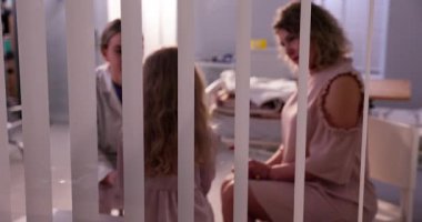 Hastanede sevgi dolu bir aile arasında dokunaklı bir an yaşanıyor, özen ve derin bir bağ vurgulanıyor.