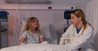 Genç bir hasta hastane ortamında, empati ve desteği yansıtan şefkatli bir doktorla iletişim kurar..